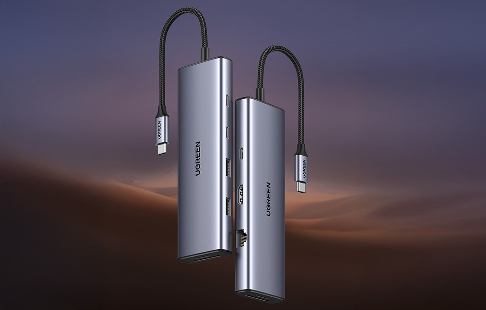 Dwa huby UGREEN z przewodami USB-C unoszące się obok siebie na tle zachmurzonego nieba.