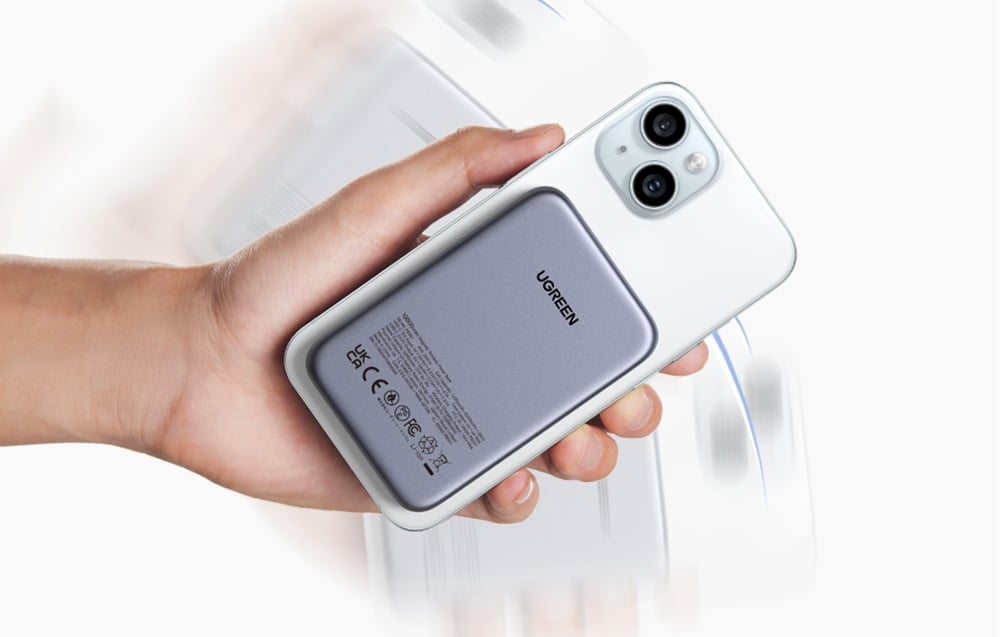 dłoń trzymająca smartfona z przymocowanym powerbankiem magnetycznym