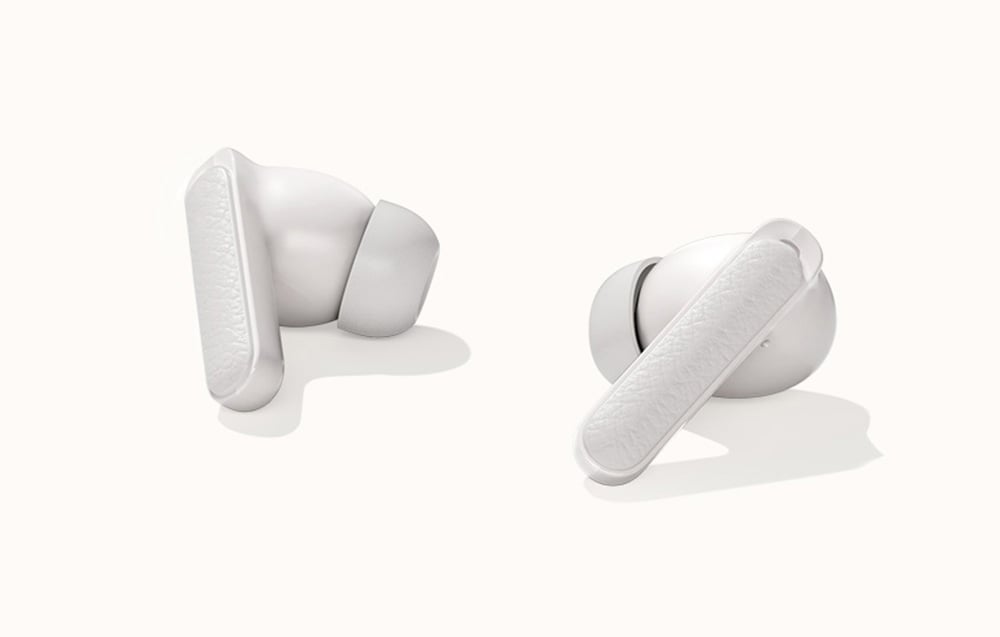 Białe słuchawki bezprzewodowe z tłoczoną fakturą, pokazane na jasnym, neutralnym tle.