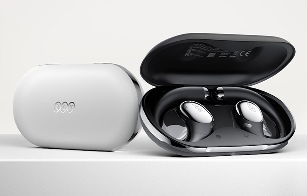 Zamknięte białe etui ładujące obok otwartego czarnego etui ze słuchawkami bezprzewodowymi z zaczepiami za ucho.