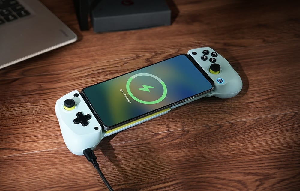 Smartfon ładujący się w kontrolerze GameSir zamontowanym na drewnianej powierzchni.