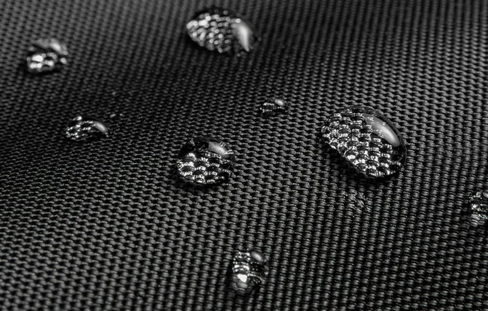 Krople wody na czarnej wodoodpornej powierzchni tkaniny