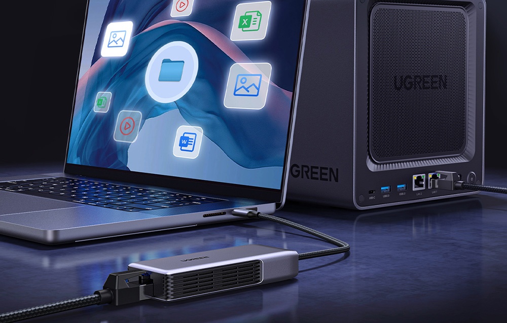 MacBook connected to a gray network adapter on a dark desk