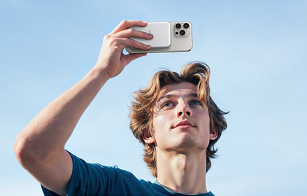 A young man recording video with a smartphone connected to the drive enclosure