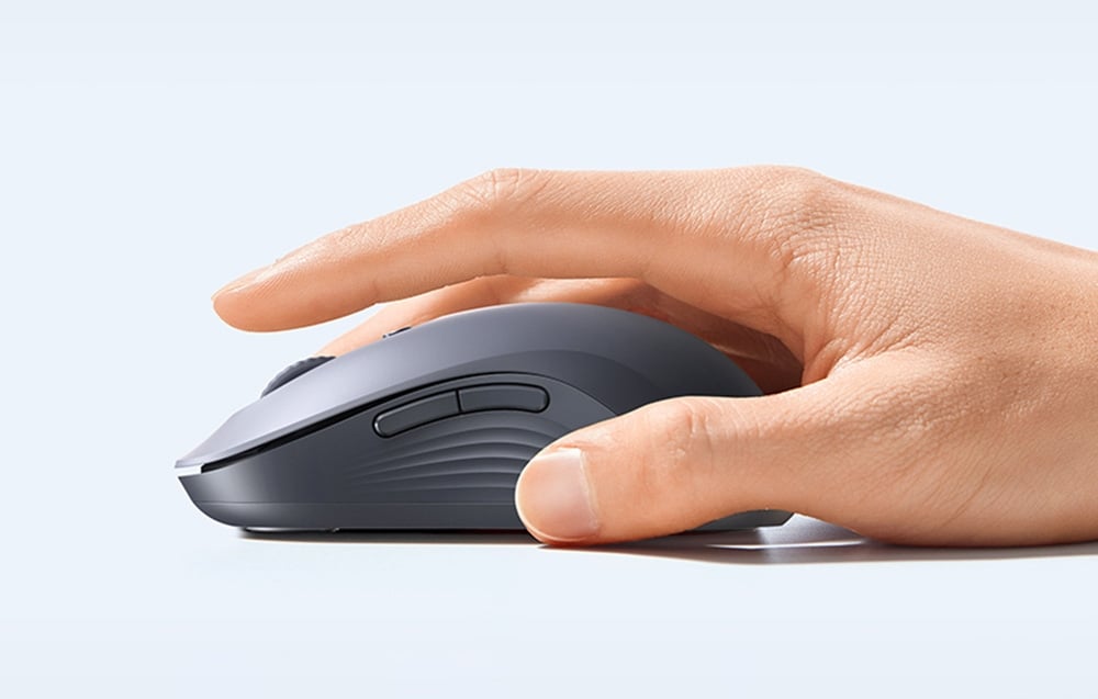 dłoń na szarej myszy komputerowej na jasnym tle