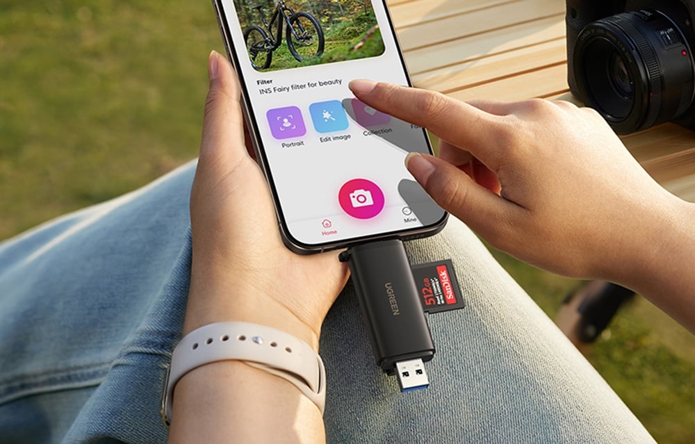 memory card reader connected to a smartphone with a photo app held in hands