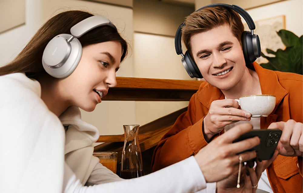 Chłopak i dziewczyna ze słuchawkami na głowach oglądający razem film na smartfonie