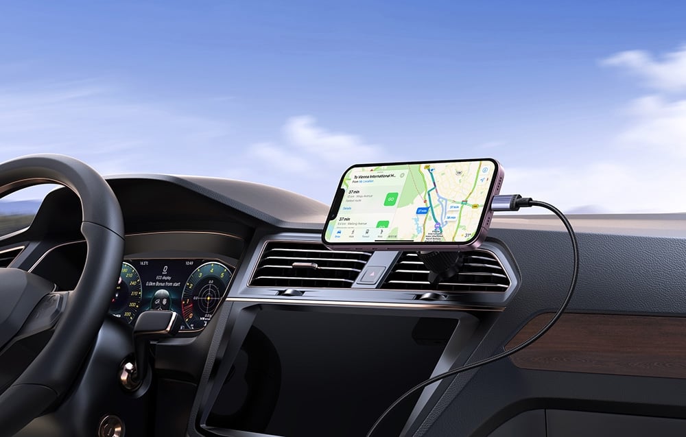 iPhone with navigation map mounted on the car dashboard with a charging cable
