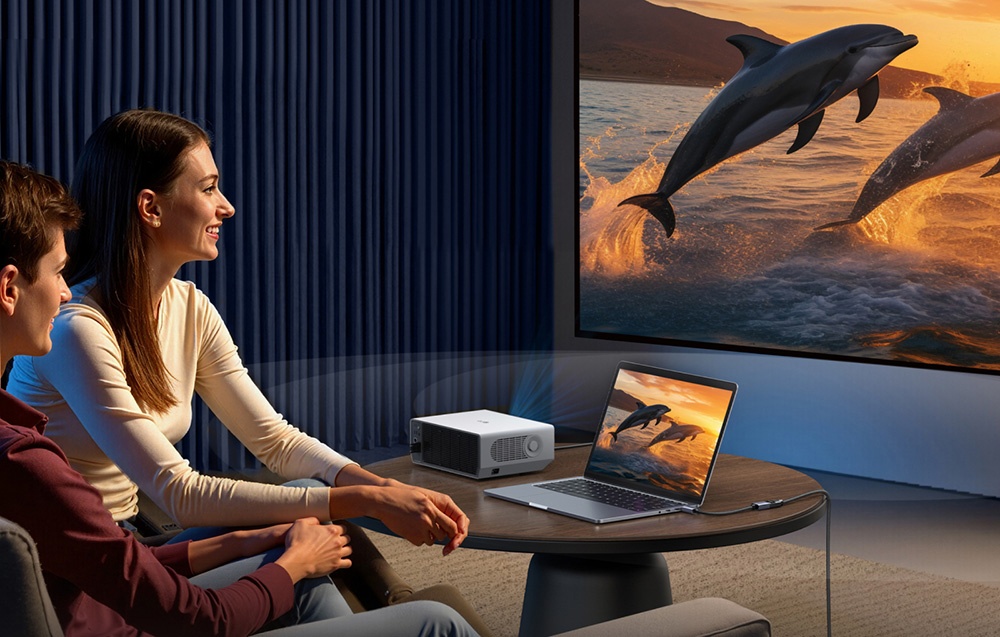 Kobieta i dziecko oglądają obraz z delfinami na dużym ekranie, obok projektor i laptop na stoliku kawowym