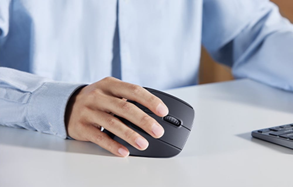 Dłoń mężczyzny obsługująca klasyczną czarną myszkę komputerową UGREEN