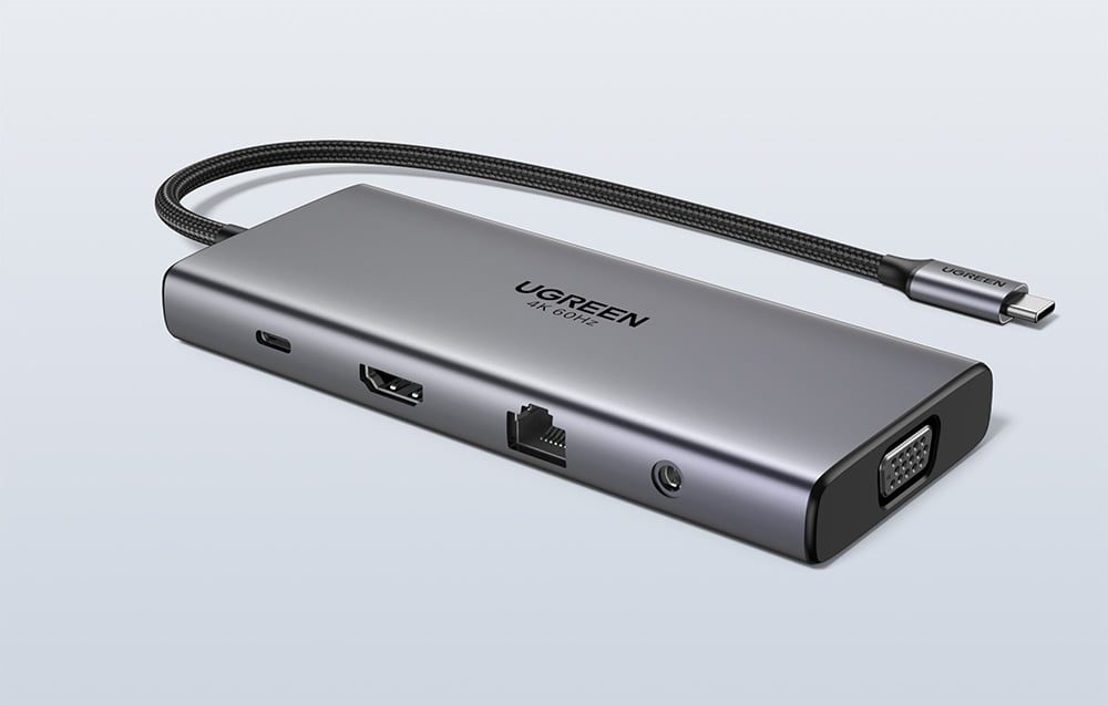 Srebrny hub UGREEN z widocznymi portami i kablem na szarym tle