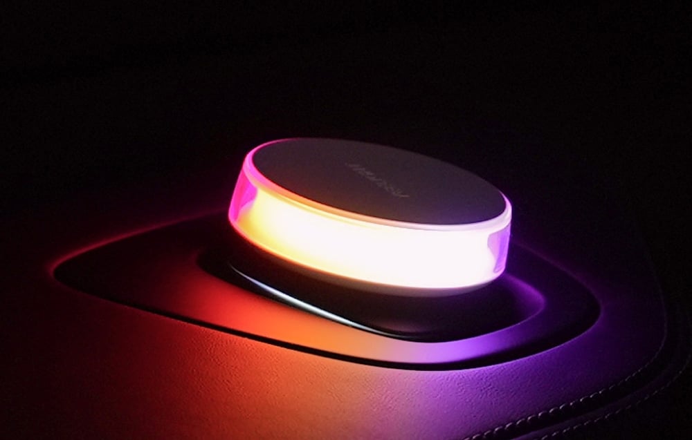 Lampka Yeelight Vega w samochodzie, świecąca intensywnym różowo-pomarańczowym światłem.