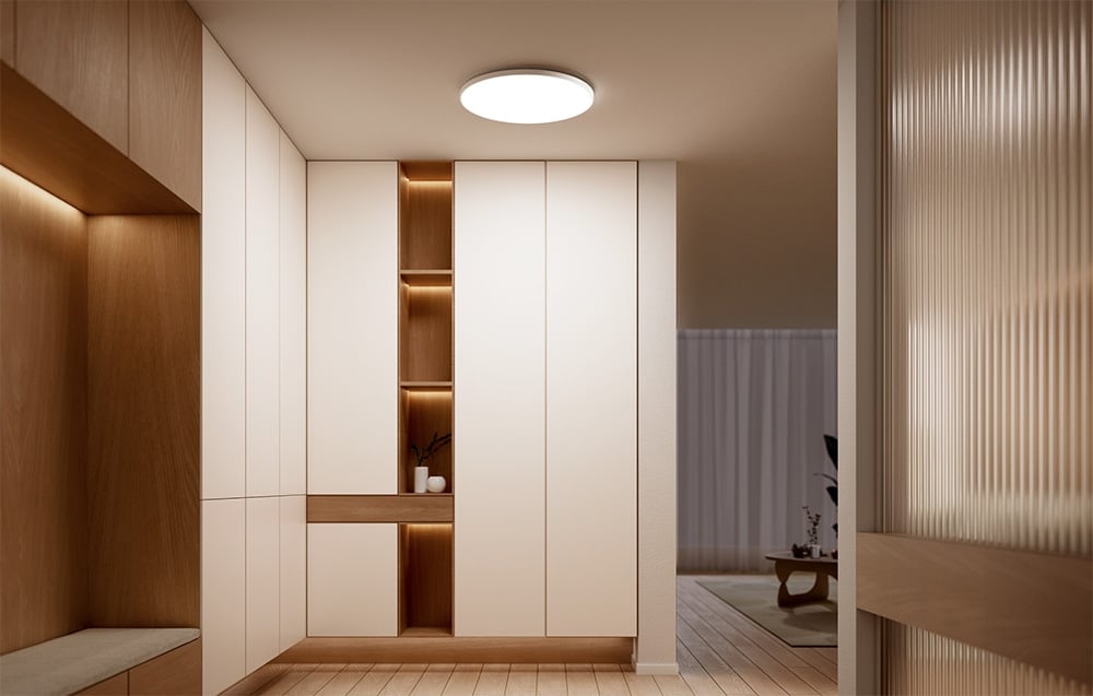 Korytarz z szafami wnękowymi i włączoną inteligentną lampą sufitową Yeelight Mercury C300.