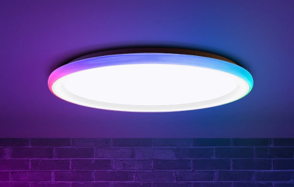 Lampa sufitowa Yeelight Mars C300 świecąca białym i kolorowym światłem na tle ceglanej ściany.
