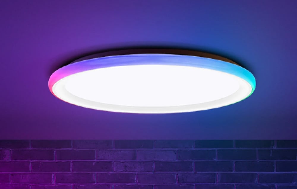 Lampa sufitowa Yeelight Mars C400 świecąca białym i kolorowym światłem na tle ceglanej ściany.