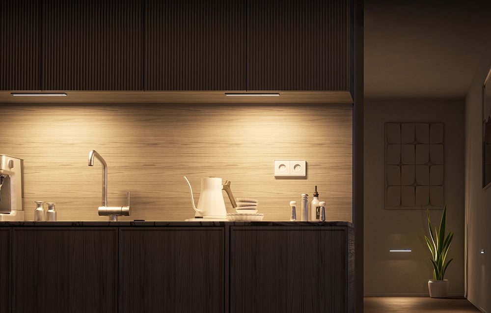 Dwie lampki do szafy Yeelight zamontowane pod szafkami kuchennymi oświetlające blat.