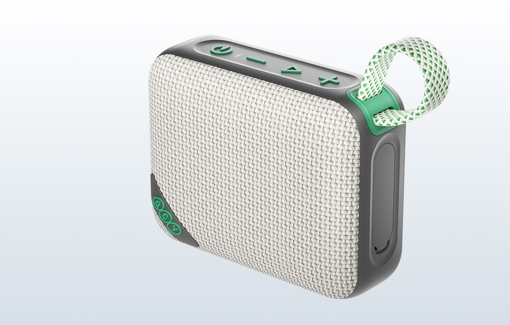 Beżowy głośnik Bluetooth z zieloną taśmą na szarym tle