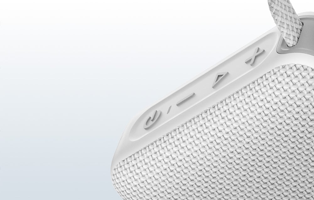 Zbliżenie na przyciski szarego głośnika Bluetooth na jasnym tle