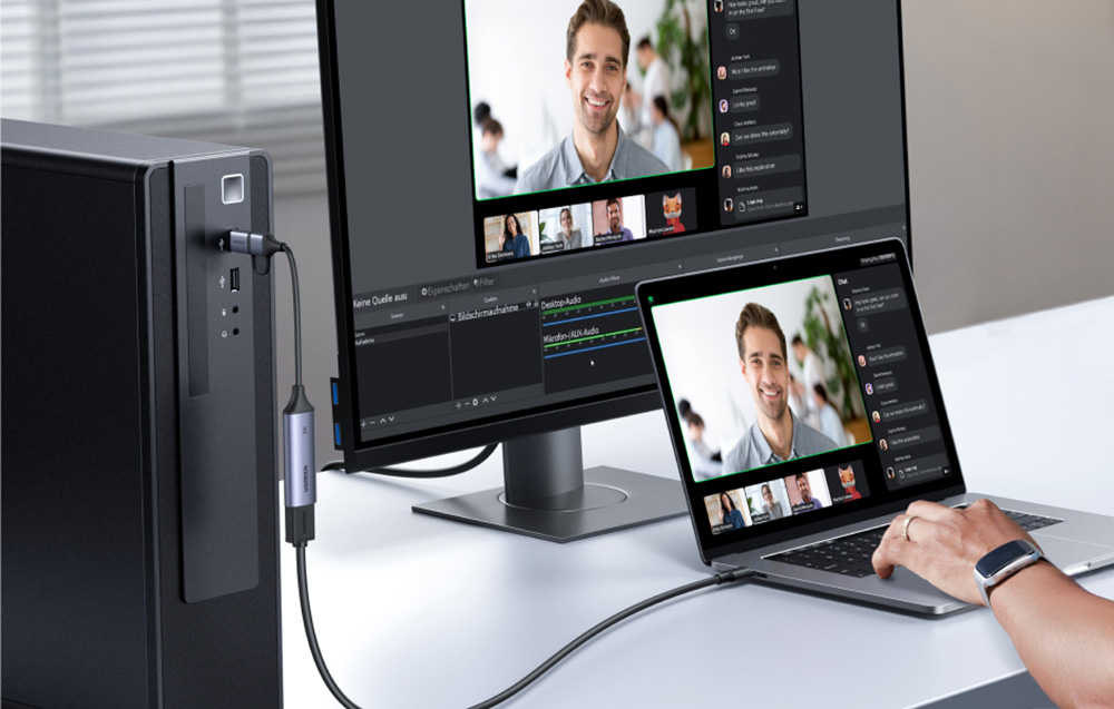 Ugreen CM629 video capture card connected to a computer and laptop displaying a video call.