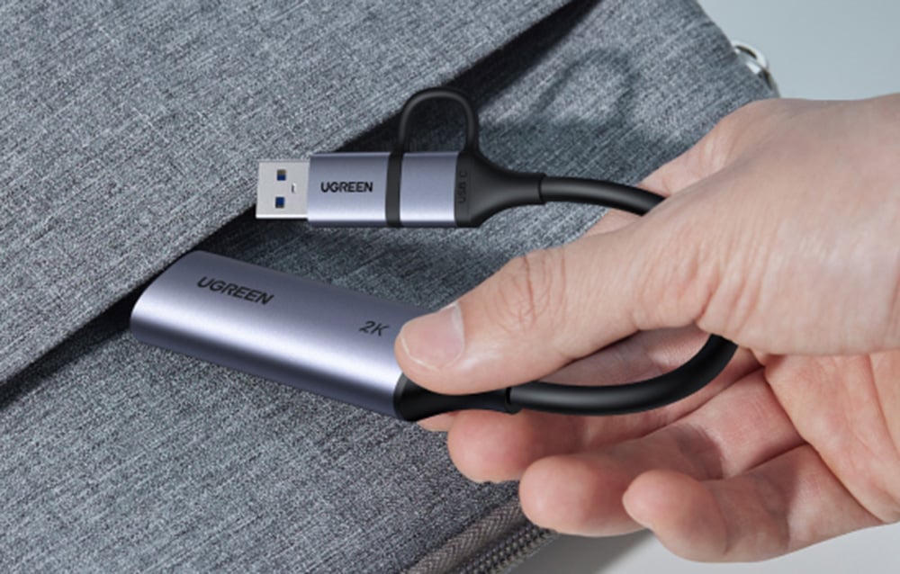 Ugreen CM629 video capture card being pulled out of a gray bag.