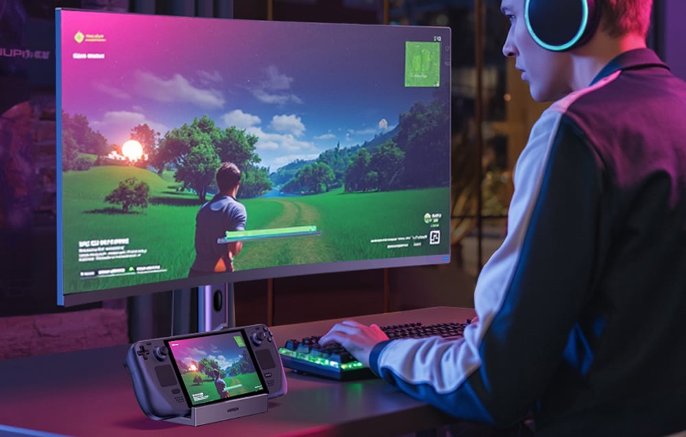 Mężczyzna grający w grę komputerową na komputerze i konsoli do gier, która stoi na adapterze Ugreen CM800.