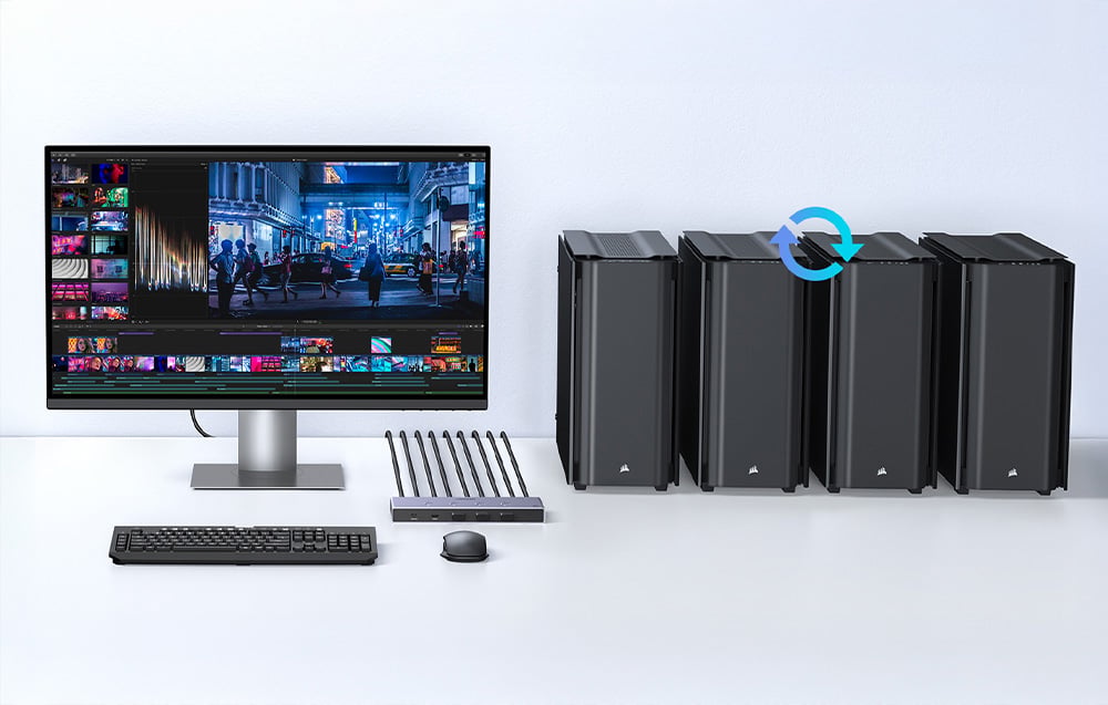 Monitor cu program de montaj lângă patru computere negre, cu un mouse și o tastatură în față