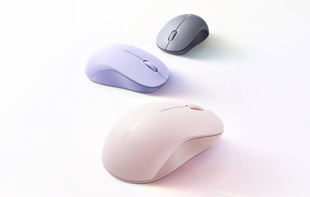 Trzy myszy bezprzewodowe Ugreen M331 w różowym, fioletowym i szarym kolorze na białym tle.