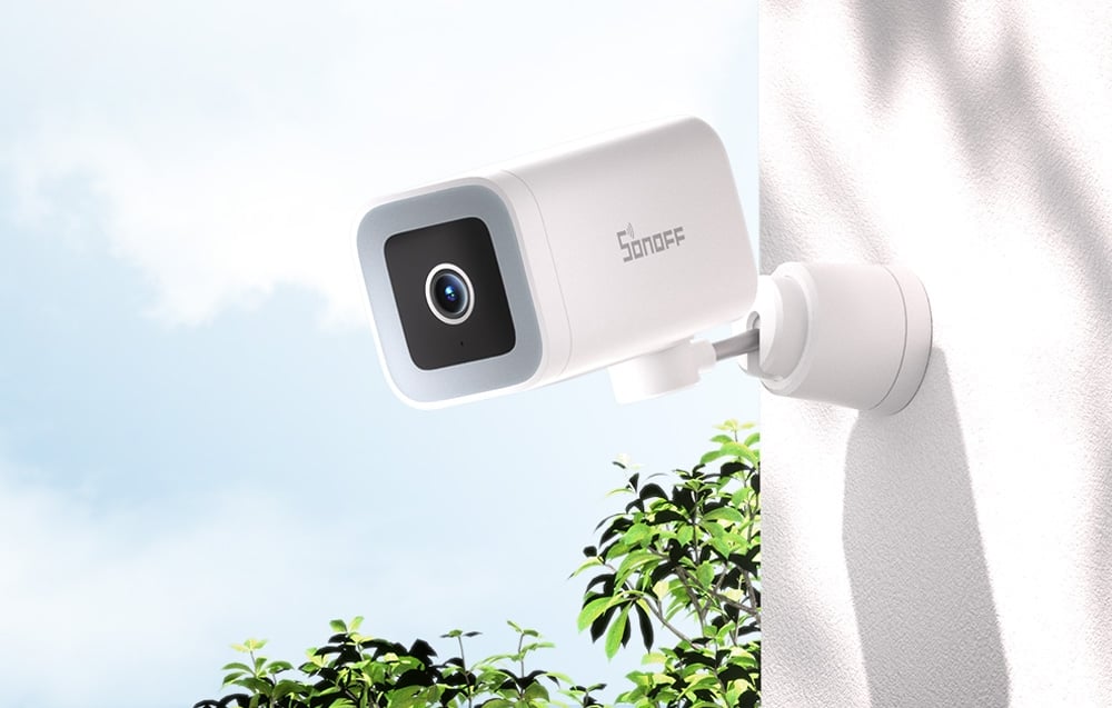 Biała kamera zewnętrzna SONOFF zamontowana na ścianie domu