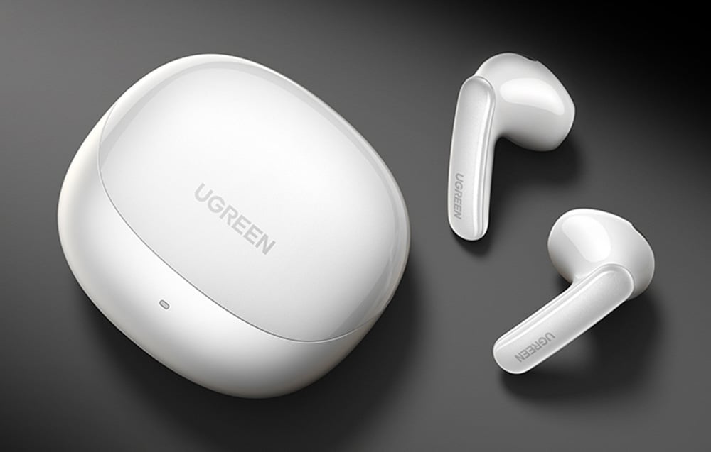 Białe bezprzewodowe słuchawki douszne UGREEN leżą obok zamkniętego etui na czarnym tle