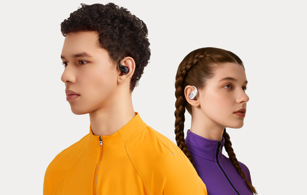 Kobieta i mężczyzna w sportowych ubraniach noszą bezprzewodowe słuchawki douszne z pałąkiem