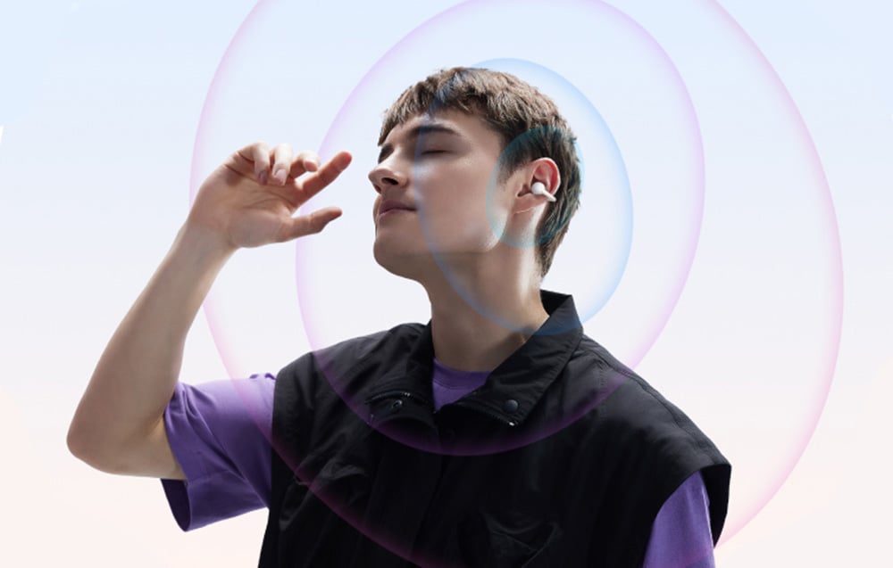 Mężczyzna z zamkniętymi oczami nosi bezprzewodowe słuchawki douszne, otoczony kolorowymi falami dźwiękowymi