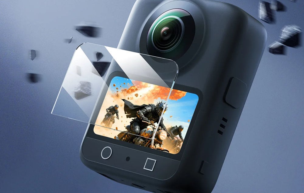 360°-Kamera mit gehärteter Bildschirmabdeckung in einer dynamischen Szene, mit fliegenden Splittern, die die Schlagfestigkeit symbolisieren