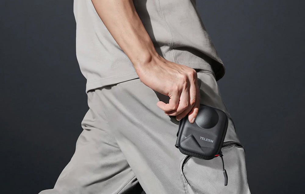 Person in grauer Kleidung steckt die TELESIN Hülle in die Hosentasche