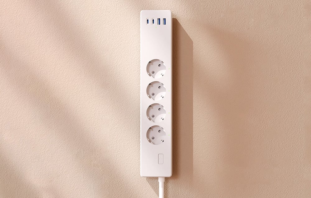 Widok z góry na pustą listwę zasilającą z czterema gniazdami i pięcioma portami USB, zamontowaną na ścianie