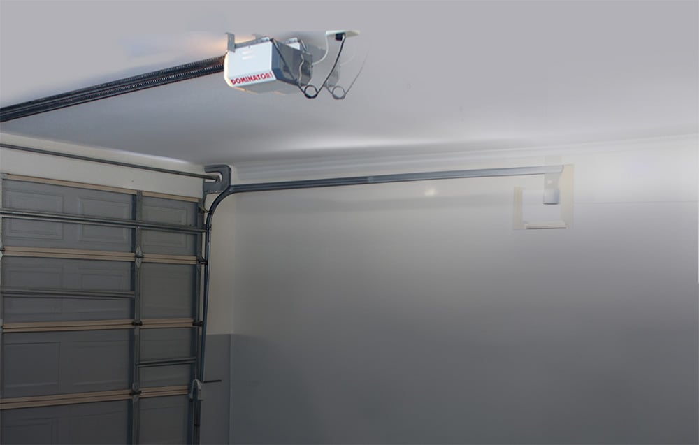Inside a garage with a closed door and a ceiling drive from Dominator