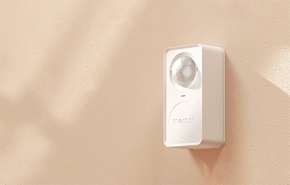 Biały czujnik ruchu Meross zamontowany na beżowej ścianie