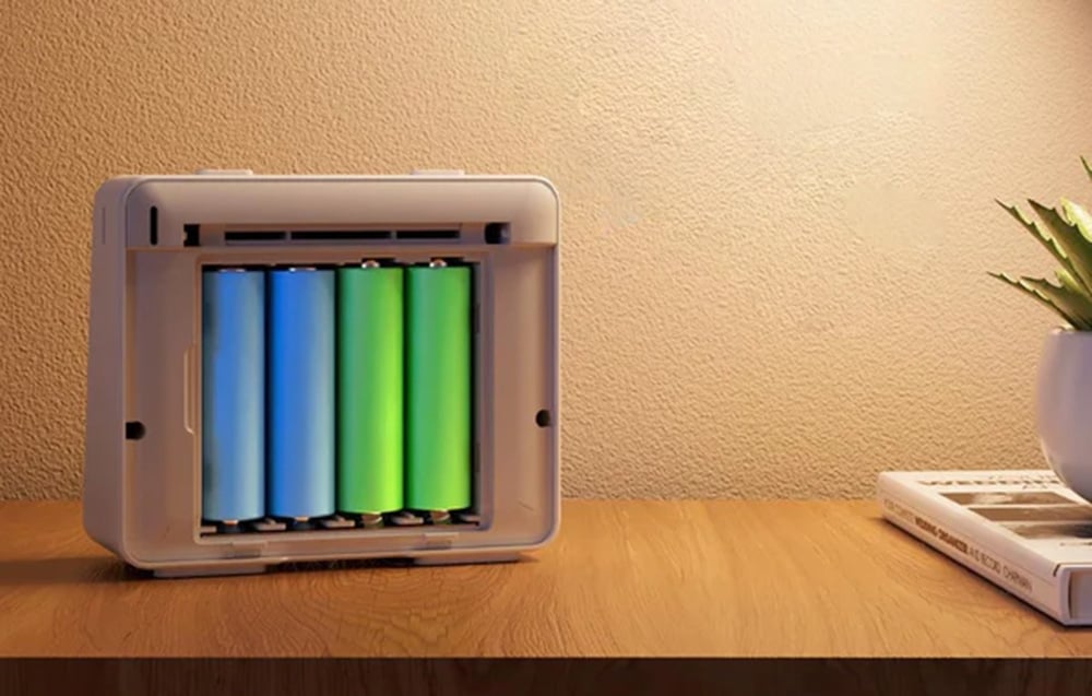 Tył zegara Meross z widocznymi czterema kolorowymi akumulatorami umieszczonymi w komorze baterii