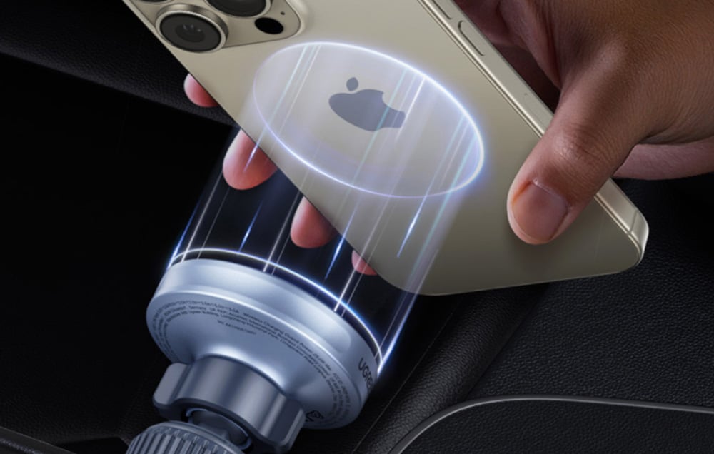 Zbliżenie na moment przyłożenia iPhone’a do magnetycznej ładowarki samochodowej UGREEN, z efektem świetlnym wokół urządzenia