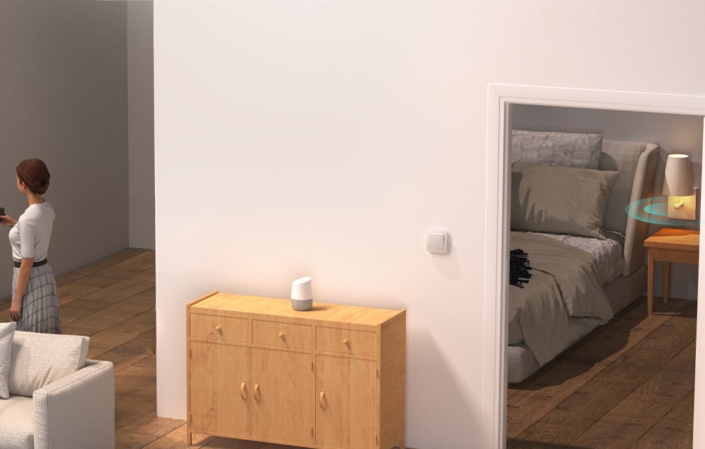 Kobieta w salonie z widokiem na sypialnię, gdzie lampa nocna jest sterowana automatycznie