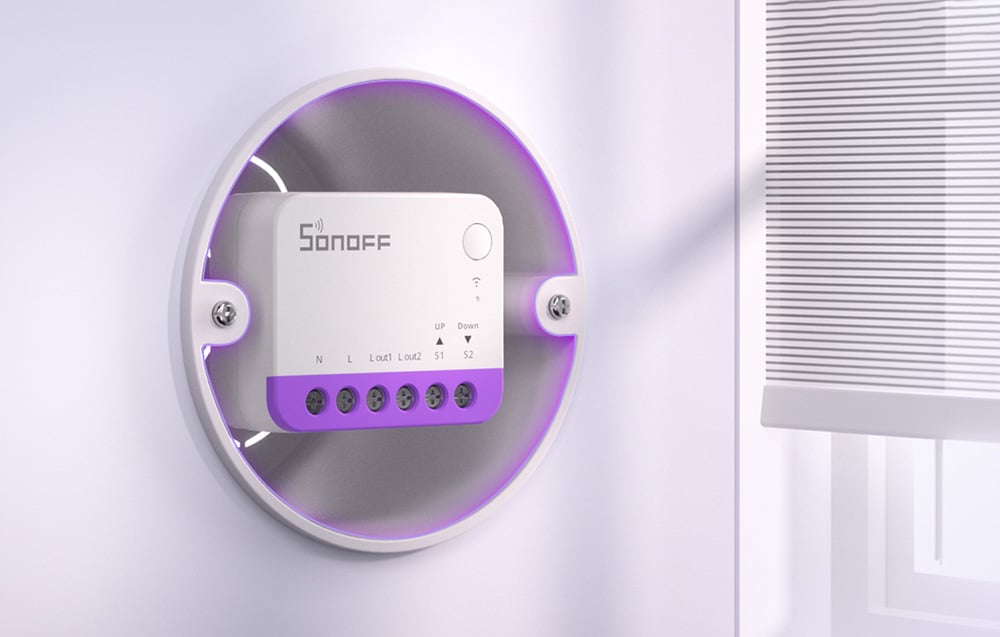 Zbliżenie modułu Sonoff z fioletową obudową zamontowanego w okrągłej ramce na białej ścianie