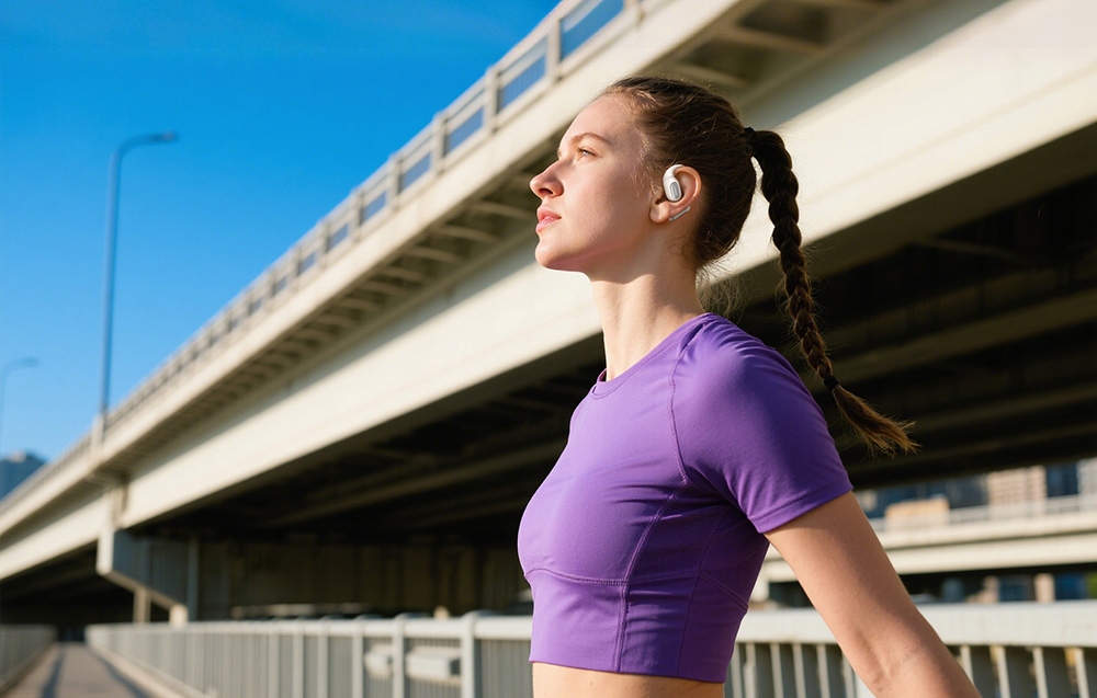 Dziewczyna w fioletowej koszulce i z białymi słuchawkami w uszach przed mostem