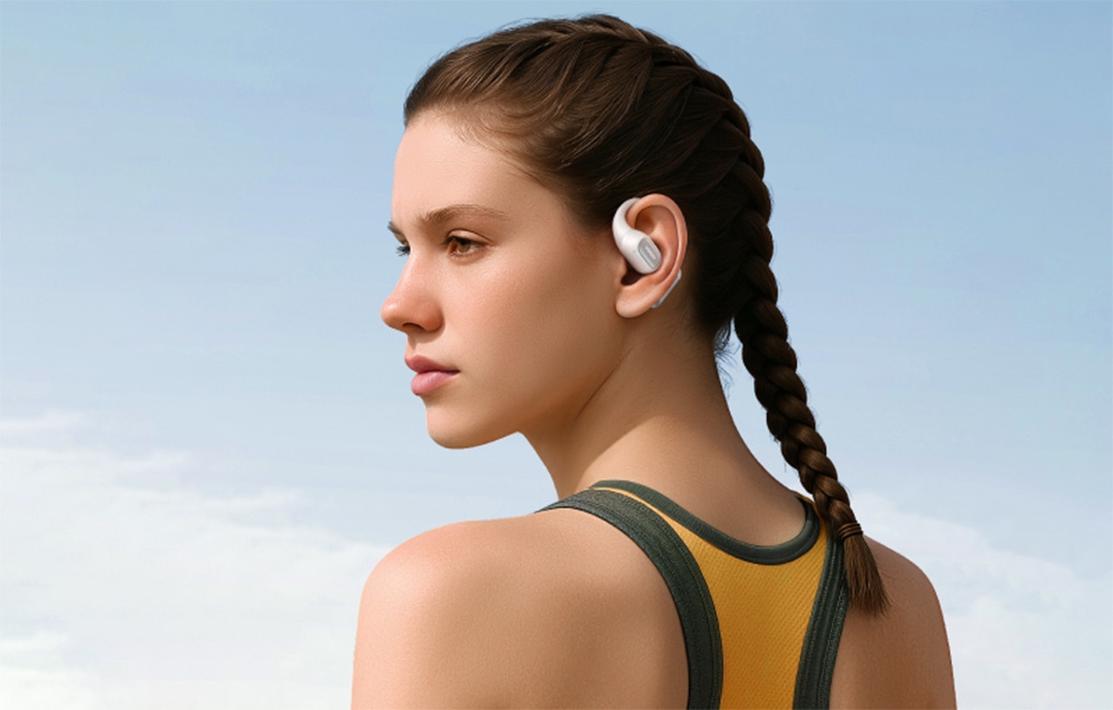 Dziewczyna w sportowym topie i białymi słuchawkami w uszach na tle nieba