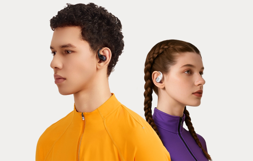 Chłopak i dziewczyna słuchający muzyki ze słuchawek bezprzewodowych na szarym tle