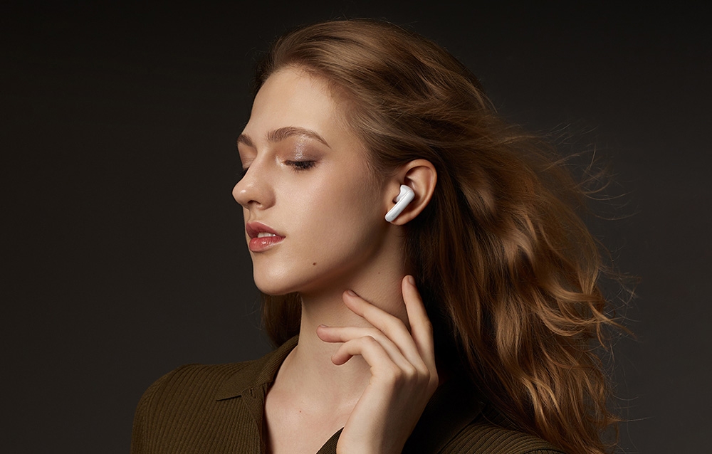 Dziewczyna z białą słuchawką bezprzewodową w uchu na czarnym tle