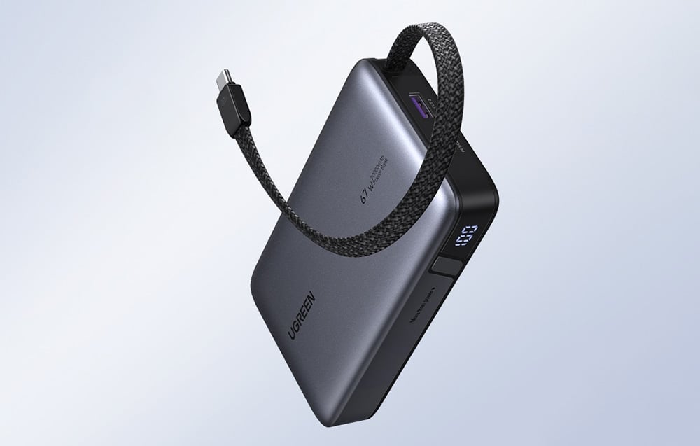 Graue Powerbank Ugreen mit Kabel auf einem grauen Hintergrund