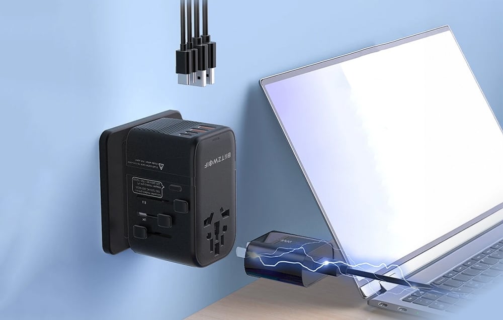 Adapter Blitzwolf podłączony do gniazda zasilania. Obok laptop na drewnianym biurku