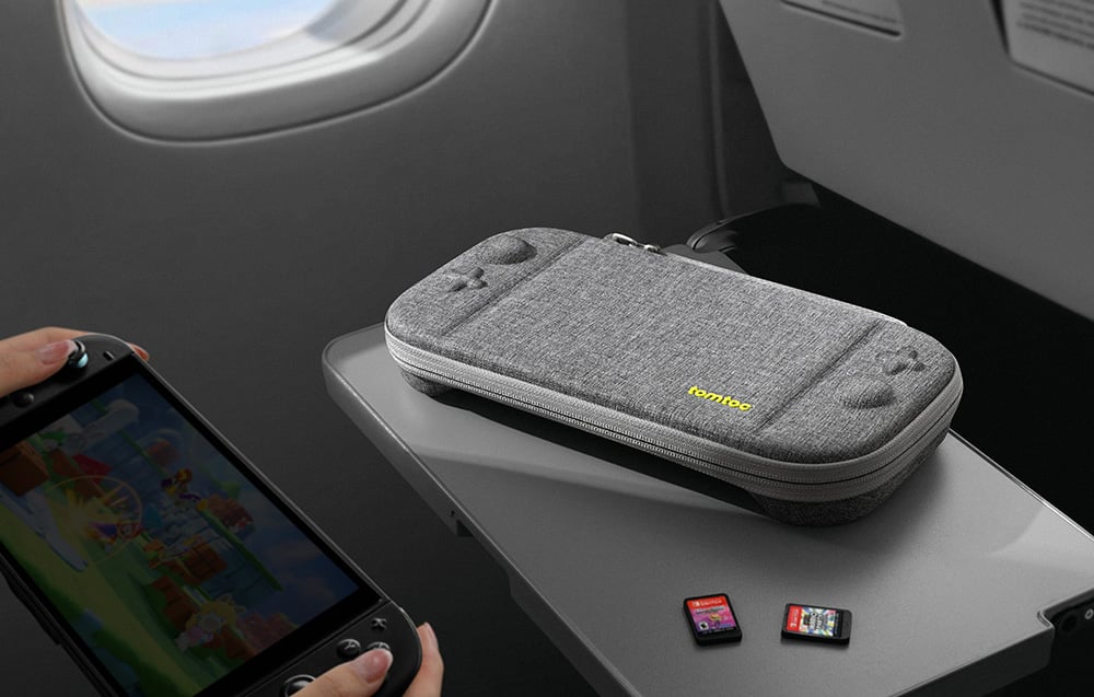 Gray portable console case with game cards on a table in an airplane
