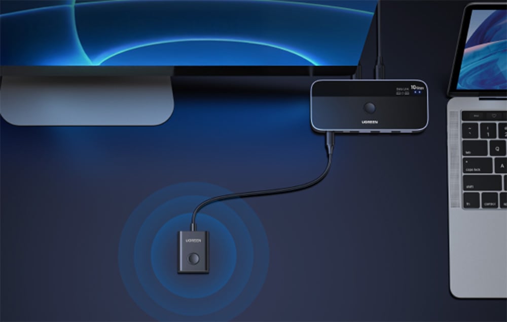 KVM-Switch von UGREEN, kabelgebunden mit Laptop und Monitor auf einem Schreibtisch verbunden