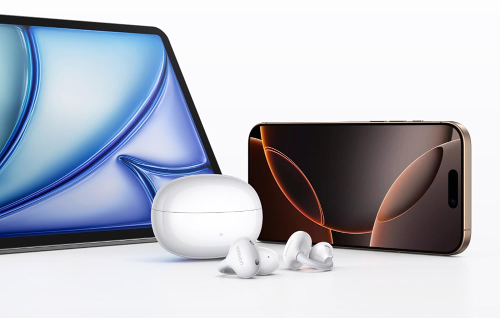 Tablet, smartfon i białe słuchawki bezprzewodowe z etui ładującym na białym stole