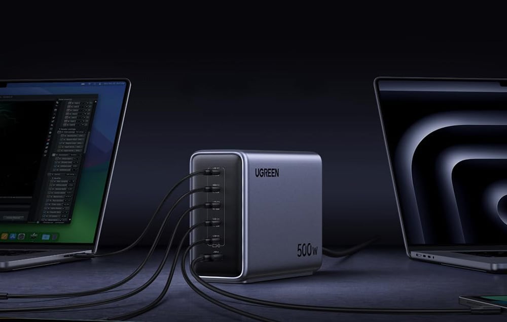 Two laptops connected to the UGREEN 500W charger on a dark desk
